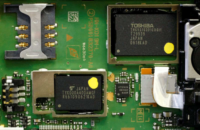 © Reuters. FILE PHOTO: Toshiba Corp chip is seen among other semiconductors and electronic components inside a Toshiba mobile phone in Tokyo