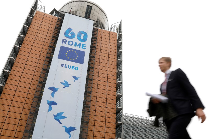 © Reuters. A man walks past the European Commission headquarters in Brussels on which is displayed a banner celebrating the 60 years after the signing of the Treaty of Rome, in Brussels