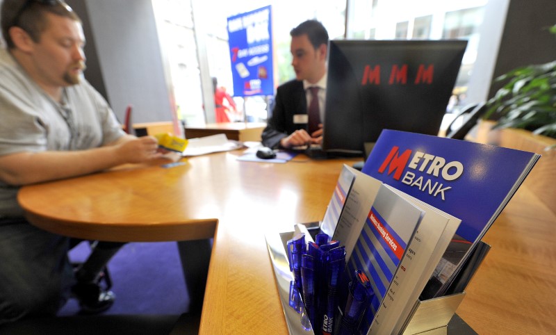 © Reuters. A member of staff serves a customer at the first branch of  Metro Bank in Holborn in central London