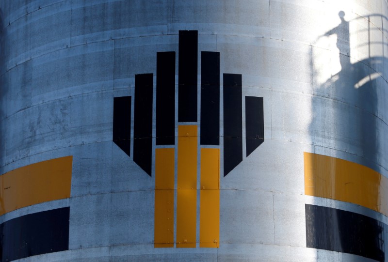 © Reuters. FILE PHOTO: The shadow of worker is seen next to the logo of Russia's Rosneft oil company at the central processing facility of Rosneft-owned Priobskoye oil field outside Nefteyugansk
