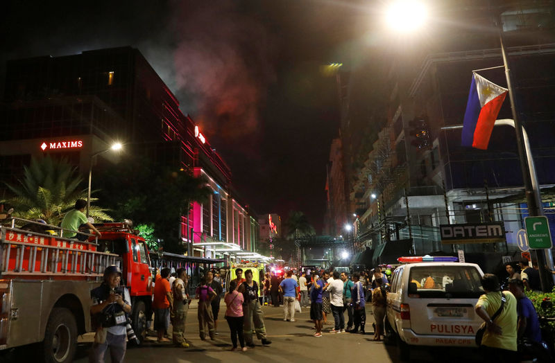 © Reuters. Funcionários e hóspedes retirados de hotel após homem armado colocar fogo em cassino em Manila, nas Filipinas