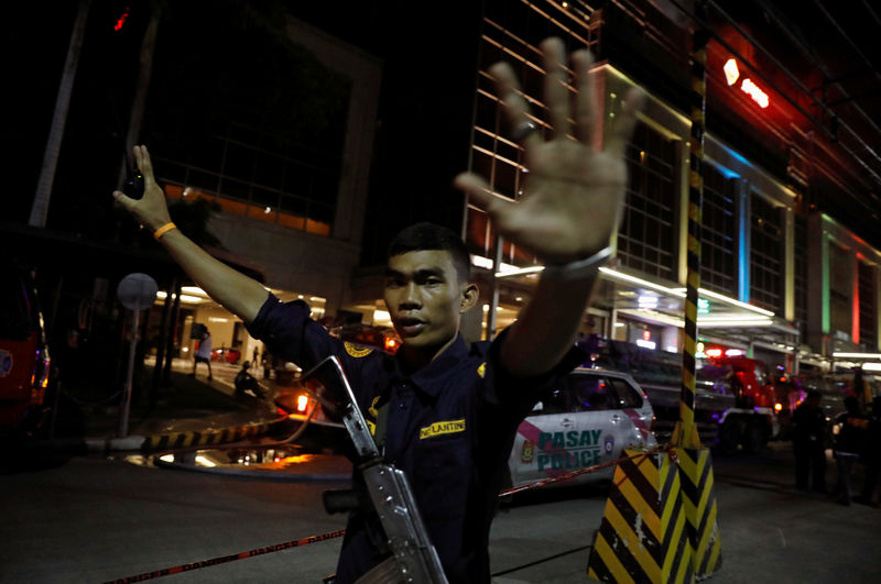 © Reuters. Guarda de segurança impede fotógrafos de se aproximarem de hotel em Manila após ataque, nas Filipinas