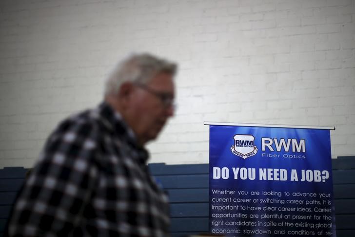 © Reuters. Homem passa por cartaz com dizeres "Você precisa de um emprego?" em Los Angeles