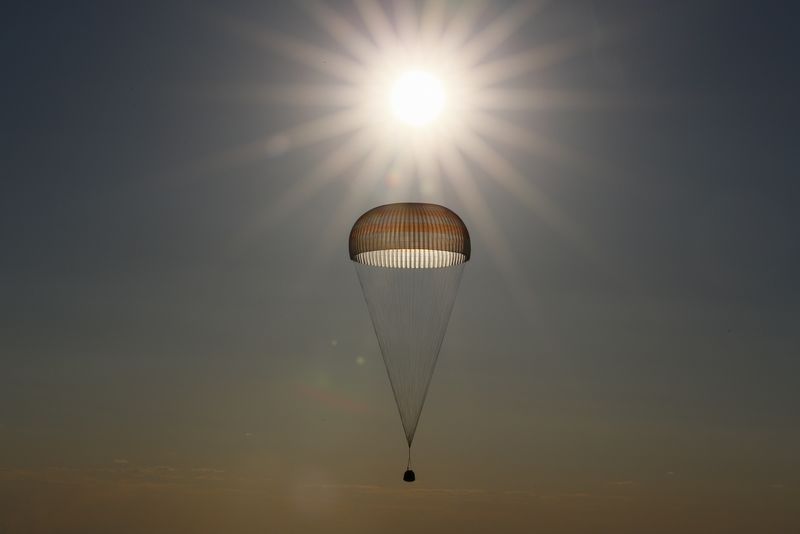 © Reuters. The Soyuz MS-03 capsule carrying the International Space Station (ISS) crew is silhouetted against the sun as it descends beneath a parachute just before landing in a remote area outside the town of Dzhezkazgan (Zhezkazgan)