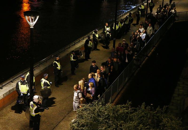 © Reuters. Police officers stand with people evacuated from the area after an incident near London Bridge in London