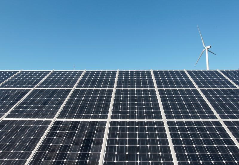 © Reuters. File photo shows a wind turbine over the panels of a solar power plant of Korea South East Power Co. (KOSEP) in Incheon