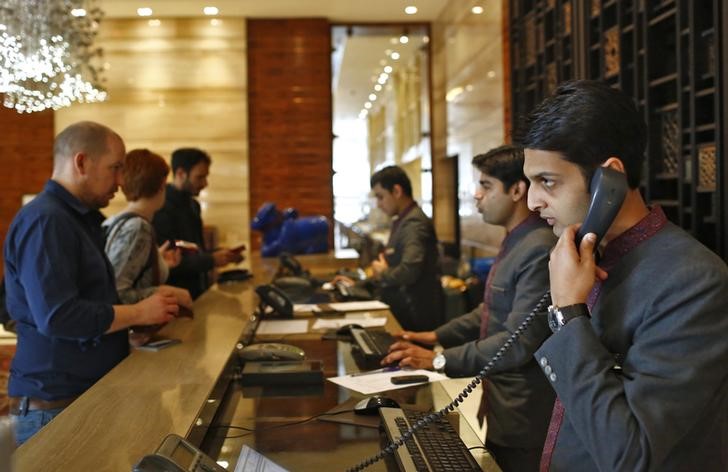 © Reuters. Receptionists attend to guests at their counter inside the Crown Plaza hotel, run by IHG, in New Delhi