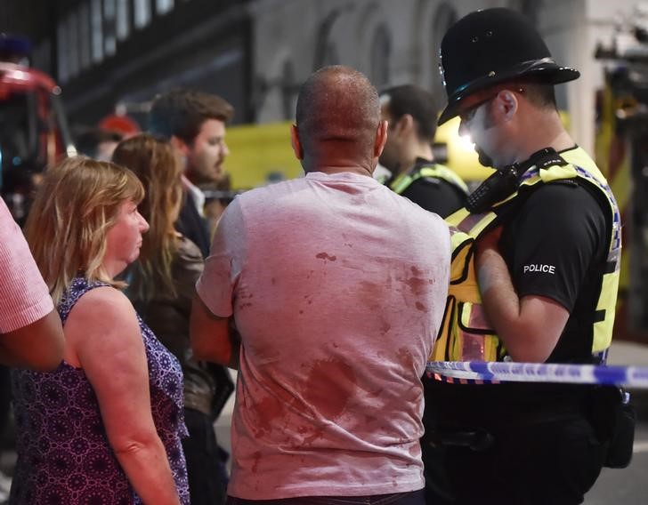 © Reuters. Gente habla con agentes de la policía después de un incidente cerca del Puente de Londres en Londres