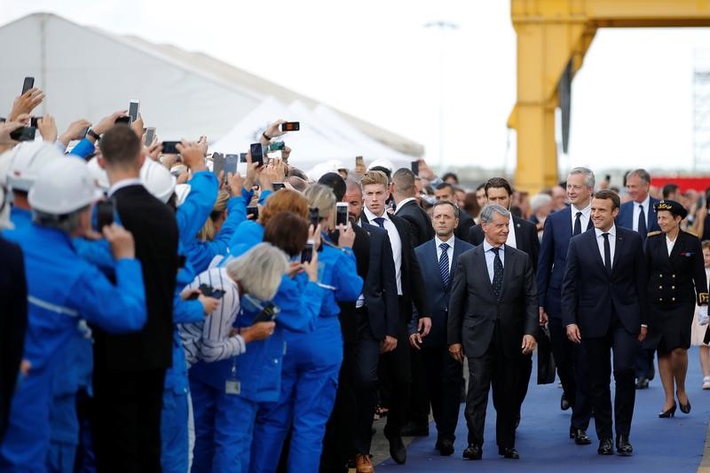 © Reuters. French President Macron walks on the blue carpet with French Economy minister Le Maire and MSC Chairman Aponte during a visit and christening of the MSC Meraviglia cruise ship in Saint-Nazaire