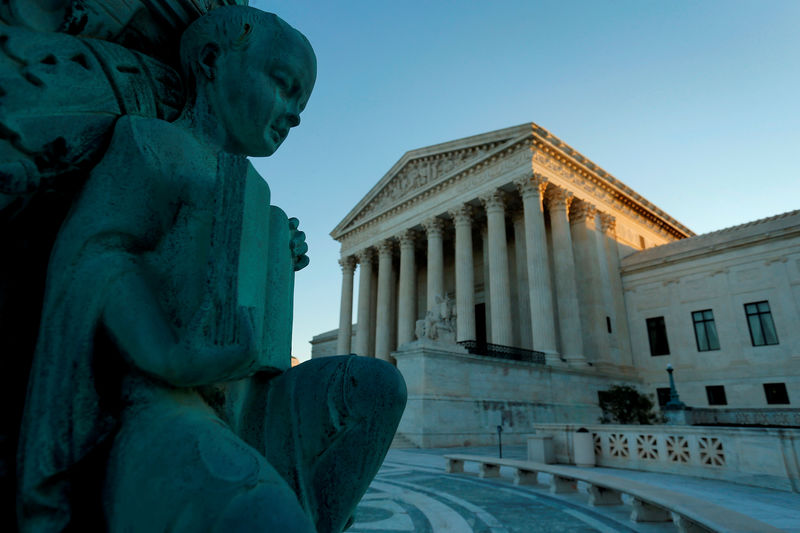 © Reuters. FILE PHOTO: A figure of a child holding an open book decorates a flagpole at the U.S. Supreme Court building in Washington