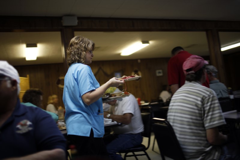 © Reuters. A waitress carries plates at a seafood restaurant in Bayou La Batre, Alabama