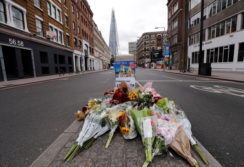 © Reuters. People stand around floral tributes on the south side of London Bridge near Borough Market after an attack left 7 people dead and dozens of injured in London