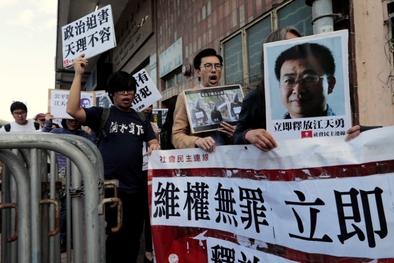 © Reuters. Pro-democracy demonstrators hold up portraits of Chinese disbarred lawyer Jiang Tianyong, demanding his release, during a demonstration outside the Chinese liaison office in Hong Kong