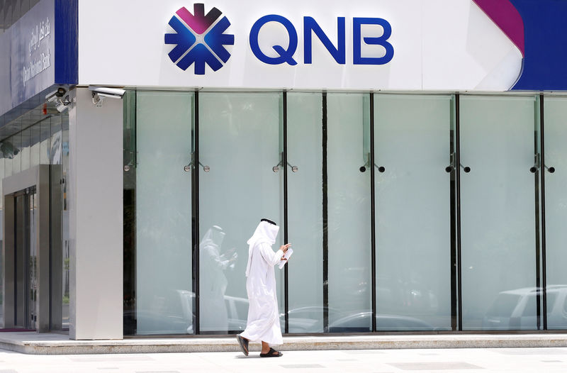 © Reuters. Man walks past a branch of Qatar National Bank in Riyadh