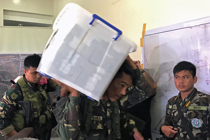 © Reuters. A government soldier carries a box containing 52.2 million pesos ($1.06 million) cash seized from a vault in a house previously controlled by militants in the Marawi city