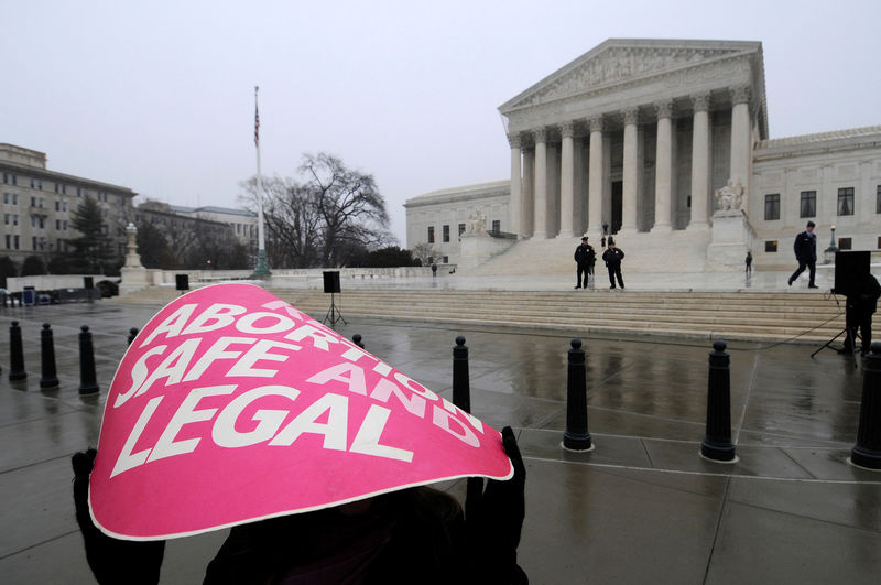 © Reuters. FILE PHOTO: A woman holds a sign in the rain as abortion rights protestors arrive to prepare for a counter protest on the 39th anniversary of the Roe vs Wade decision, in front of the U.S. Supreme Court building