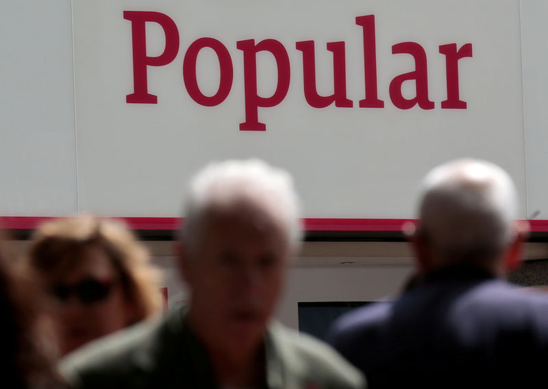 © Reuters. FILE PHOTO: People walk past a branch of Spain's Banco Popular in Madrid