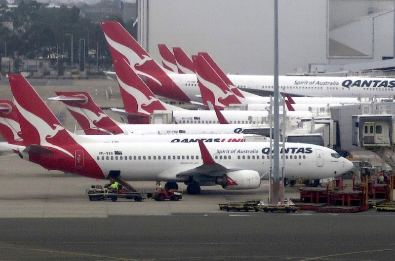 © Reuters. Groundstaff work on the tarmac next to Qantas Airways planes parked at Sydney's Domestic Airport terminal