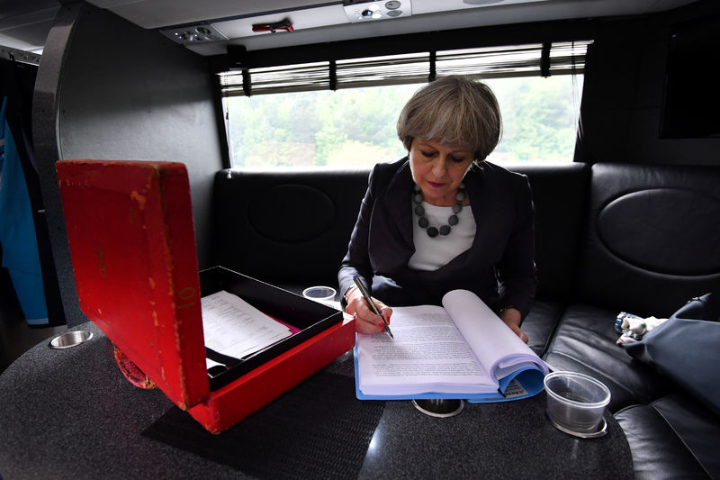 © Reuters. Britain's Prime Minister Theresa May works on her campaign bus as it travels through Staffordshire