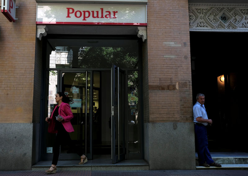 © Reuters. A woman leaves a Banco Popular branch in Madrid