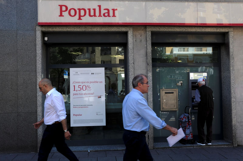 © Reuters. People walk past a Banco Popular branch in Madrid