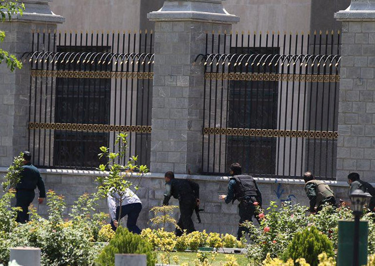 © Reuters. Membros das forças iranianas correm durante ataque ao Parlamento em Teerã