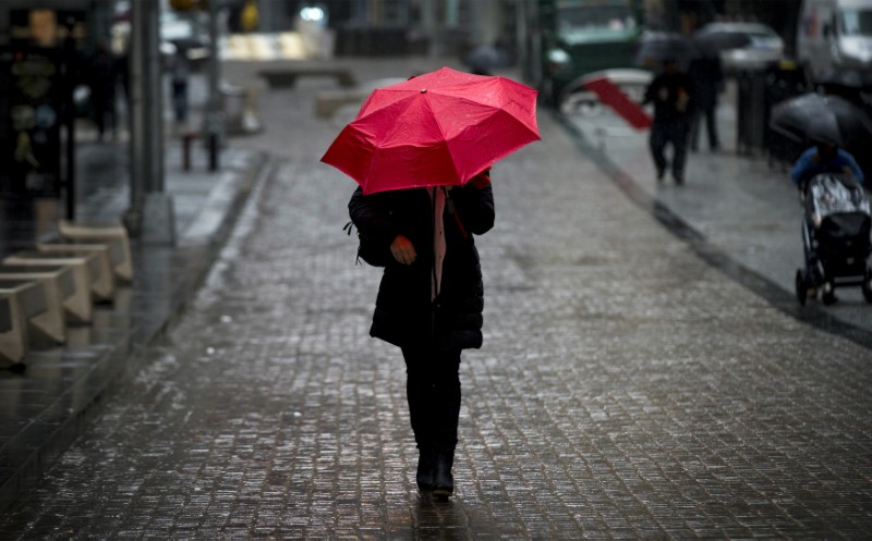 © Reuters. A woman walks on Broad St. past the New York Stock Exchange during the morning commute