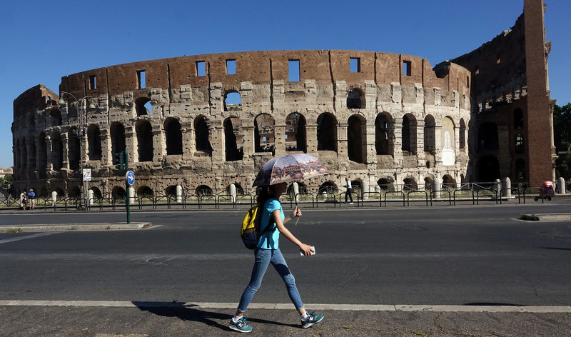 © Reuters. A woman walks past the ancient Colosseum, downtown Rome