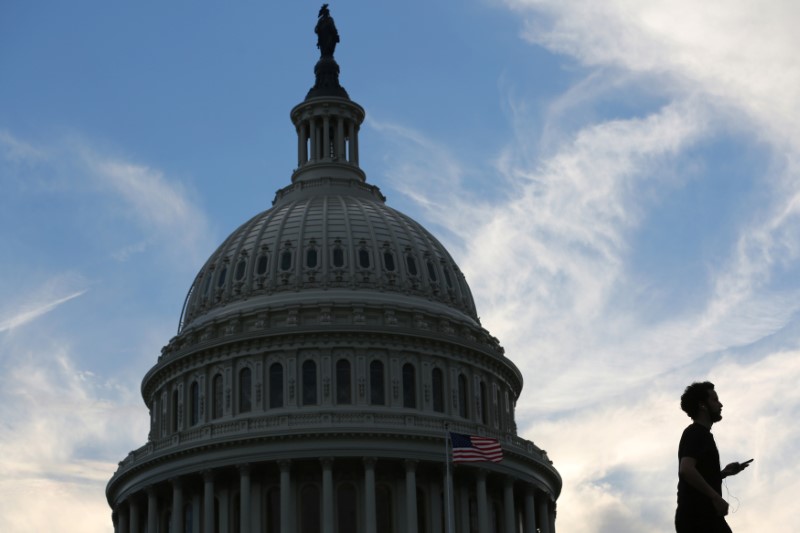 © Reuters. A man walks past the U.S. Capitol building at sunset in Washington