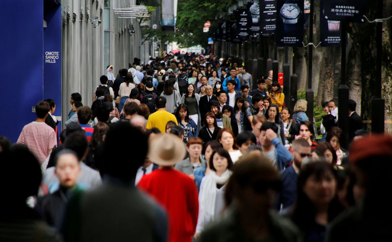 © Reuters. FILE PHOTO: People walk in Omotesando shopping district in Tokyo