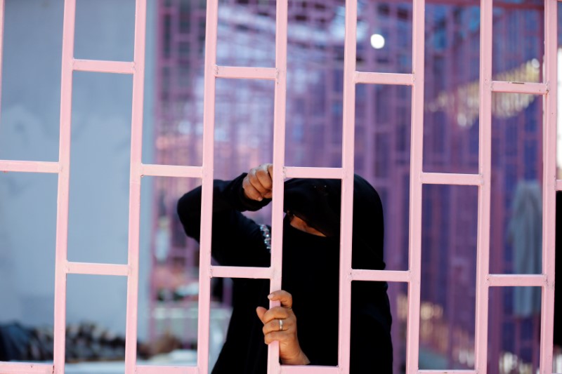 © Reuters. A woman looks from behind bars of a hospital ward allocated for cholera-infected patients in Sanaa