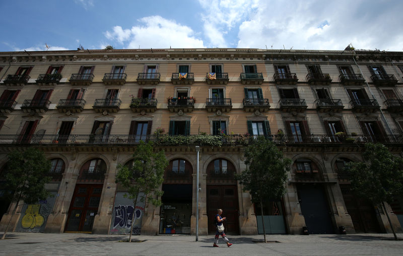 © Reuters. "Estelades" (Catalonian separatist flags) hang from balconies of a building as a woman walks past at Born district in Barcelona