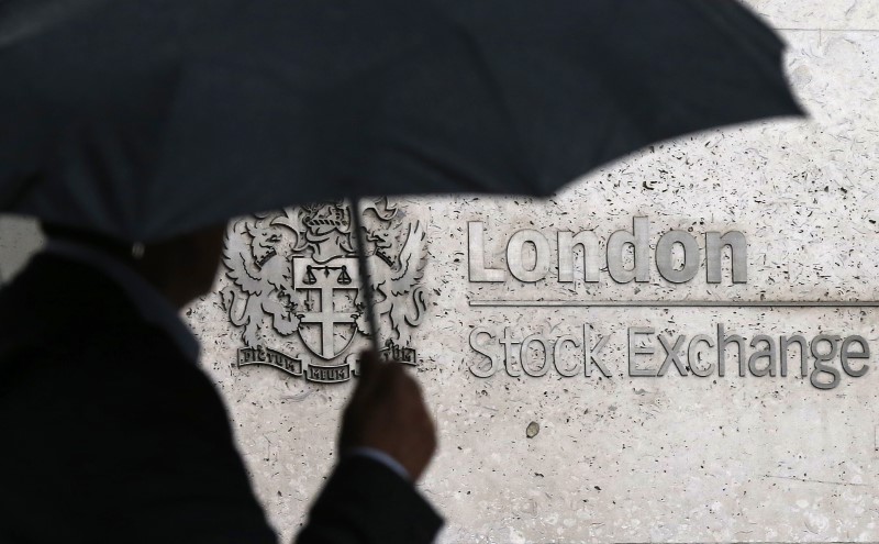 © Reuters. A man shelters under an umbrella as he walks past the London Stock Exchange