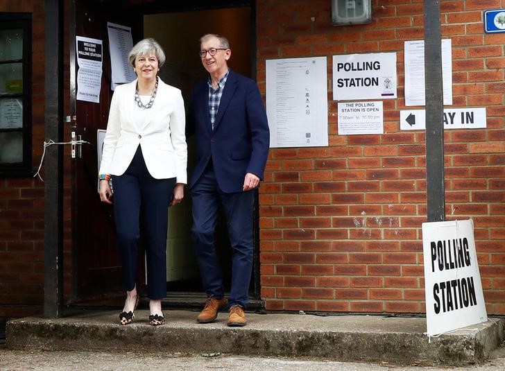 © Reuters. Premiê britânica, Theresa May, e o marido, Philip, deixam local de votação em Sonning