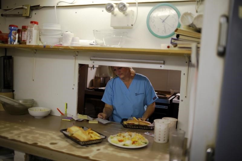 © Reuters. A waitress waits for plates in the kitchen of a restaurant in Bayou La Batre,