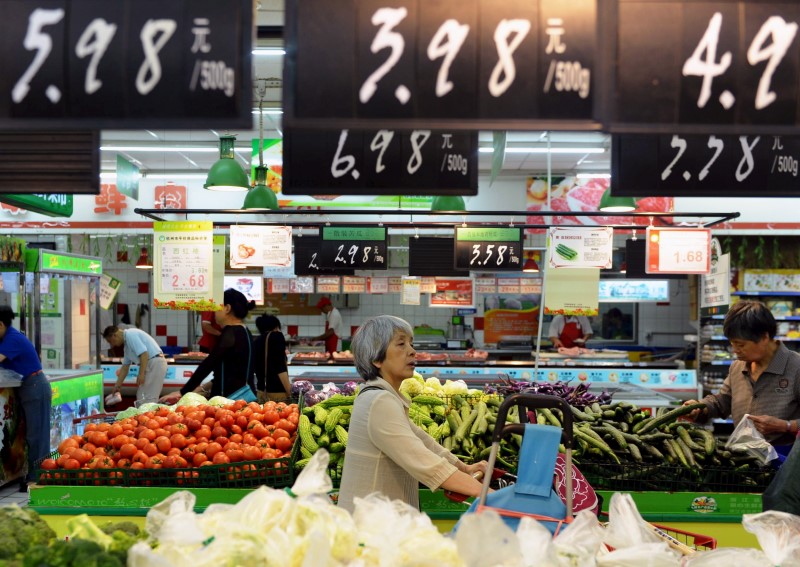 © Reuters. Customers shop for vegetables at a supermarket in Hangzhou