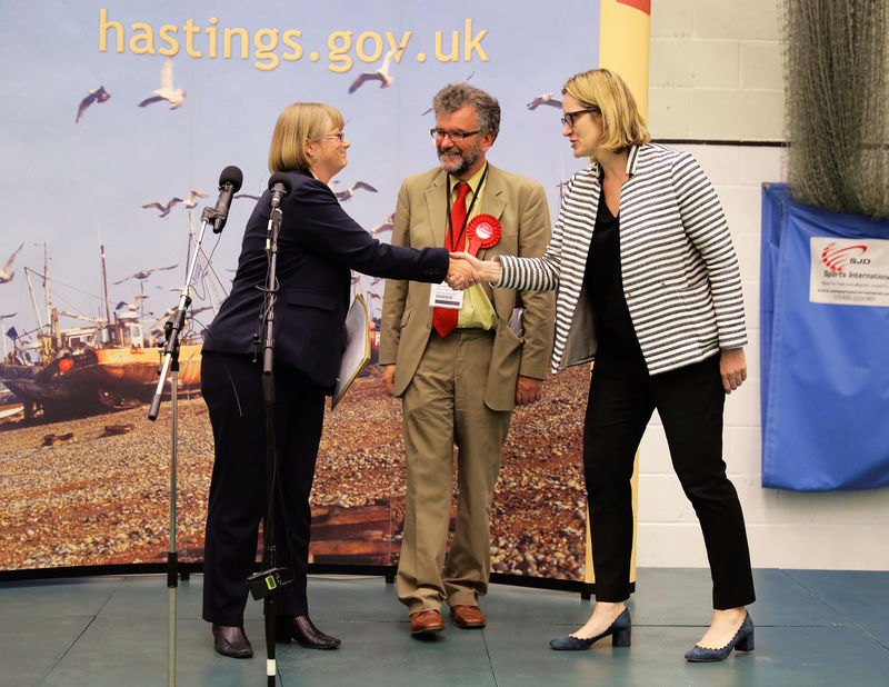 © Reuters. Britain's Home Secretary Amber Rudd's shakes hands with the returning officer after retaining her seat at a counting centre for Britain's general election in Hastings