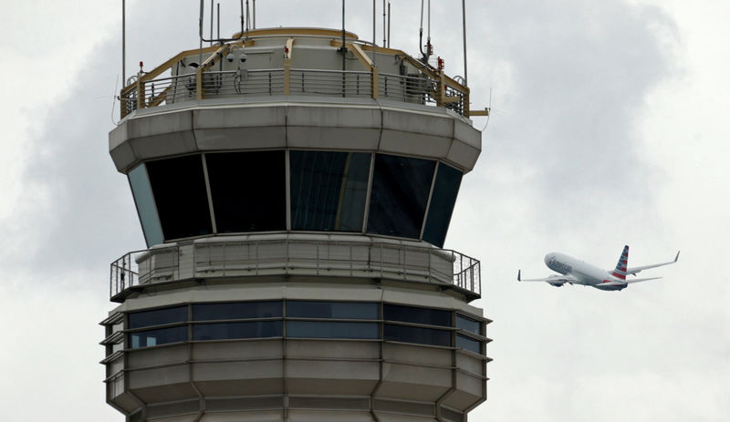 © Reuters. FILE PHOTO - A plane passes the air traffic control tower at Ronald Reagan Washington National Airport in Arlington