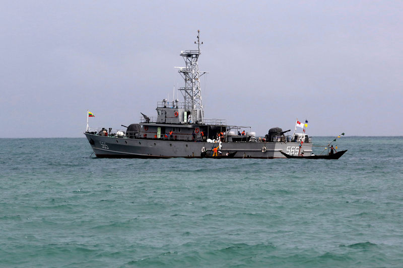 © Reuters. Rescue teams unload dead bodies from a navy vessel outside Launglon township