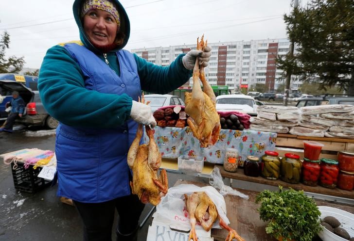 © Reuters. A foodstuff vendor reacts at street market in Krasnoyarsk