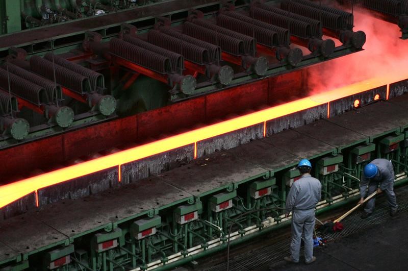 © Reuters. Chinese employees work near a machine for hot-rolled steel at the Baosteel factory in Shanghai.