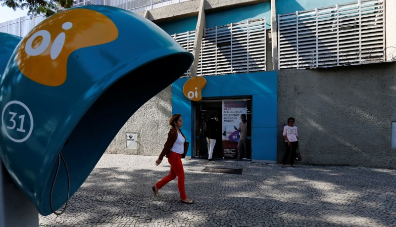 © Reuters. People walk in front of the headquarters of the Brazil's largest fixed-line telecoms group Oi, in Rio de Janeiro