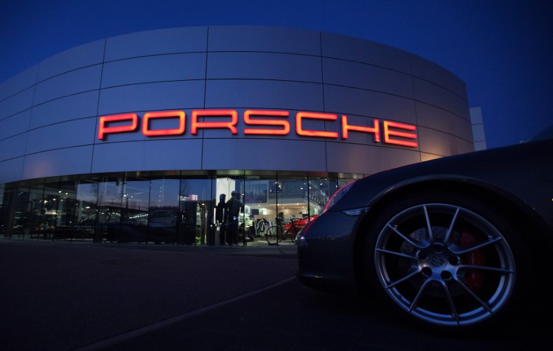 © Reuters. FILE PHOTO: An illuminated Porsche logo is pictured on a building of a Porsche retail centre in Niederwangen