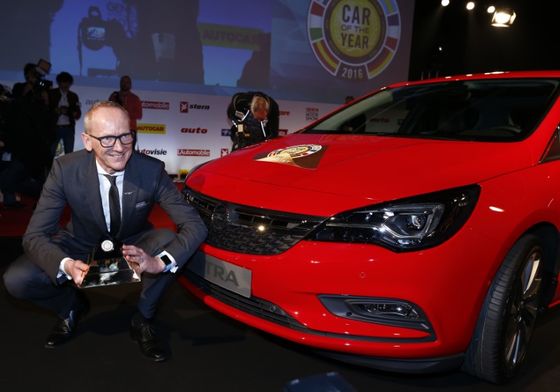 © Reuters. Neumann, CEO of Opel Group poses with the Car of the Year award next to the Opel Astra during the presentation ahead of the 86th International Motor Show at Palexpo in Geneva