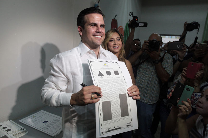 © Reuters. Puerto Rico Governor Rossello shows his ballot paper as Puerto Ricans head to the polls on Sunday to decide whether they want their struggling U.S. territory to become the 51st U.S. state, in Guaynabo