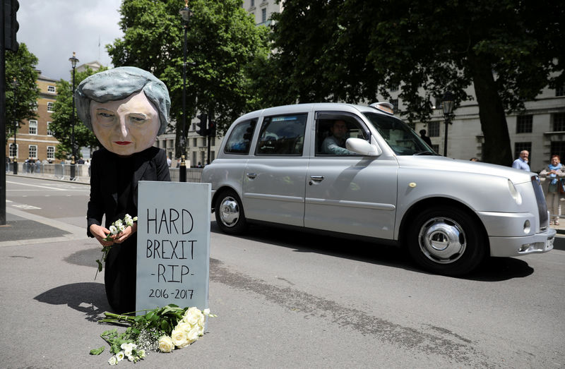 © Reuters. FILE PHOTO: A protestor wears a Theresa May mask