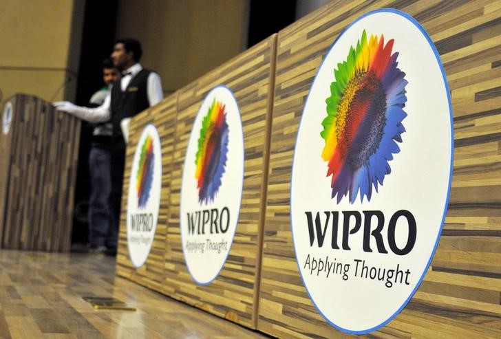 © Reuters. Stewards are seen behind the desks with a logo of India's third-largest software services firm Wipro Ltd inside the company's headquarters in Bengaluru