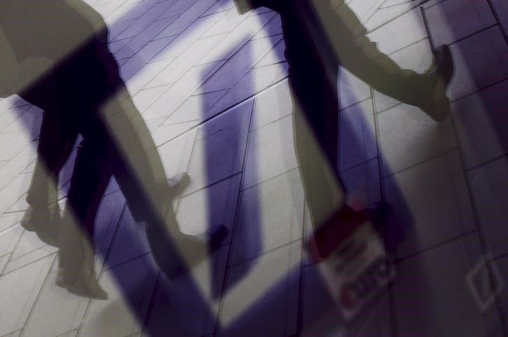 © Reuters. Pedestrians are reflected in a window as they walk in front of the headquarters of Deutsche Bank AG in Frankfurt