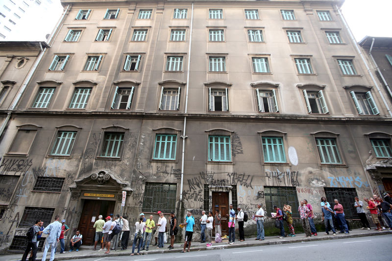 © Reuters. FILE PHOTO: Unemployed people line up in front of a charity house in downtown Sao Paulo