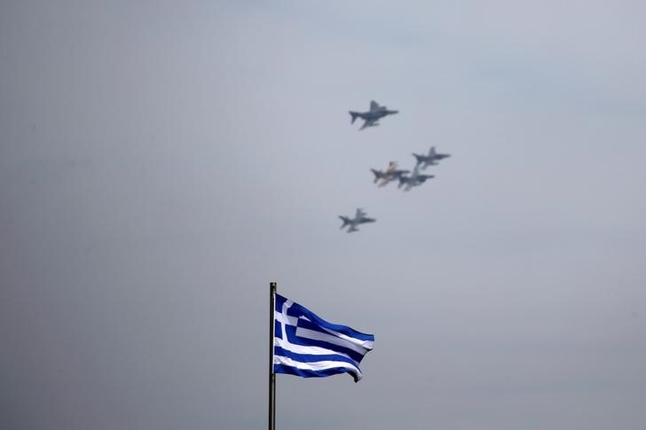 © Reuters. A Greek national flag flutters as a formation of military fighting jets fly over Athens for a photo opportunity during the International Joint Medium Scale Air Force Exercise, in Athens